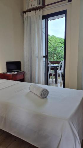 a white bed with a towel on top of it at Pousada Enseada do Corsário in Guarapari