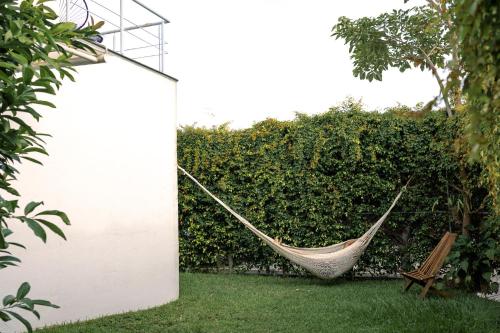 a hammock in a garden next to a hedge at Casa Viveros cerca de jardines 3 recamaras albercas y 2 estacionamientos in Jiutepec