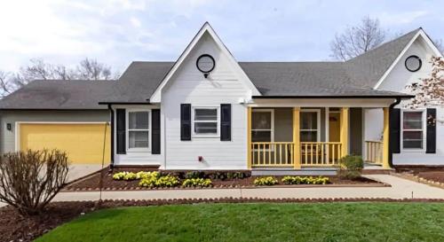 a white house with a yellow garage at Madison Luxury 4BR Theater Arcade Firepit in Madison