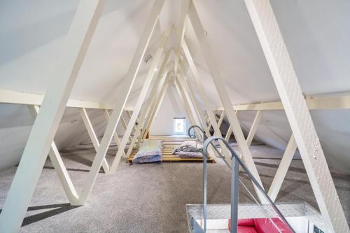 an attic room with a bed and a ladder at Studio Lodge in Crowhurst