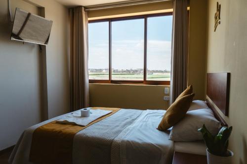 a hotel room with a bed and a window at El Sueño Del Rey in Majes