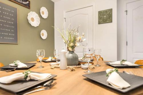 a table with glasses and a vase with flowers on it at Sunrise Tranquil Cottage 3BR RAFB Pet Friendly in Warner Robins