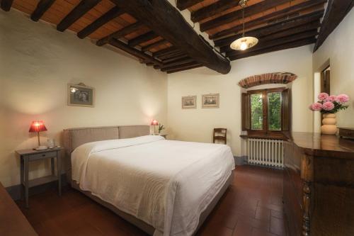 a bedroom with a white bed and a window at Castello di Albola in Radda in Chianti