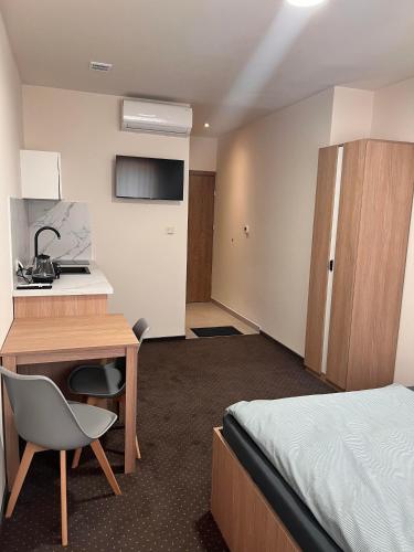 a hotel room with a bed and a desk and a kitchen at Aura Pokoje na Wynajem in Wojnicz