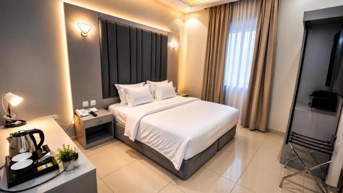 a hotel room with a bed and a television at Areen Al Naeem Served Apartments in Jeddah