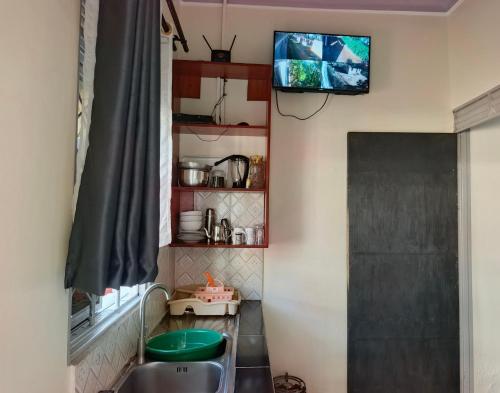 a small kitchen with a tv on the wall at JA Haven Suite in Lira