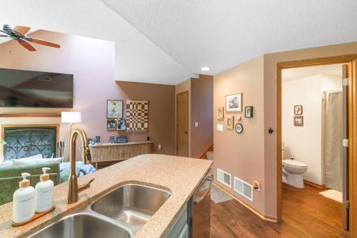 a kitchen with a sink and a living room at King Bed Fire Pit Pool & Walk to North Course in Galena