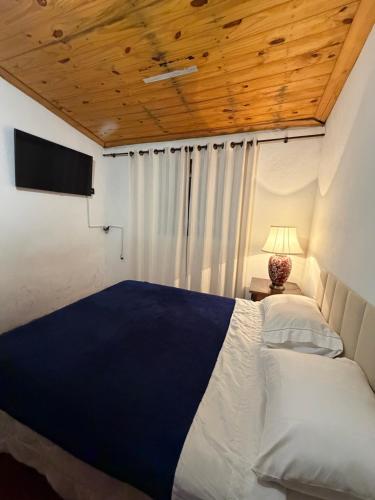 a bedroom with a bed and a television in a room at Aconchego Central in Tiradentes