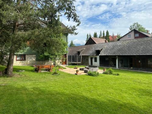 a backyard of a house with a picnic table at Podkrovie v zeleni - privat in Štrba