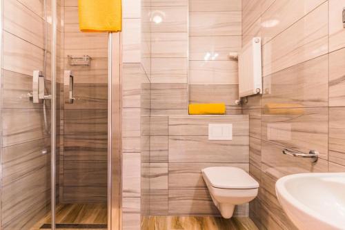 a bathroom with a toilet and a sink and a shower at Baron in Sztutowo