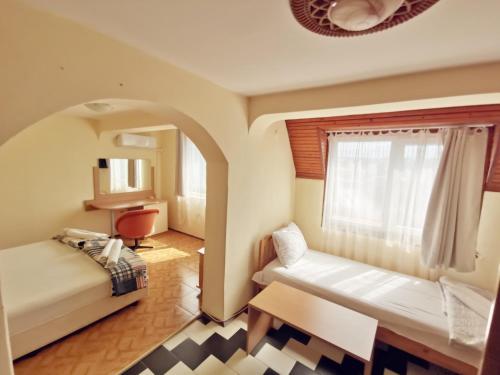 a small room with a bed and a window at Hotel VALDI in Ahtopol