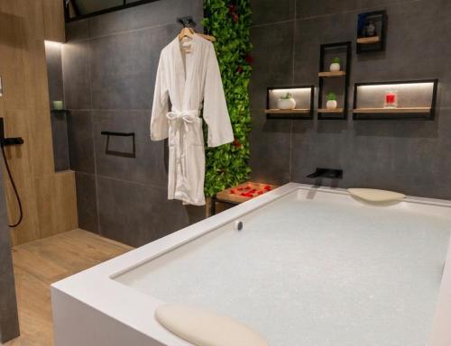 a bath tub with a robe hanging in a bathroom at Palmetto Hotel Business San Borja in Lima