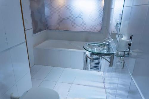 a white bathroom with a sink and a mirror at City Falls Iguazú in Puerto Iguazú