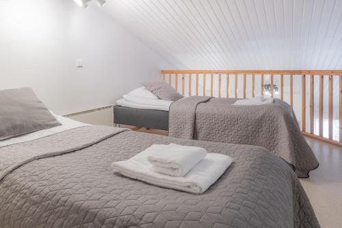 two beds with towels on them in a bedroom at Kisala, Vuokatti I Huippu sijainti in Vuokatti