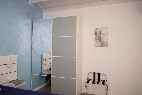 a bedroom with a glass closet with a chair in it at Casa Terry in Ronchi dei Legionari