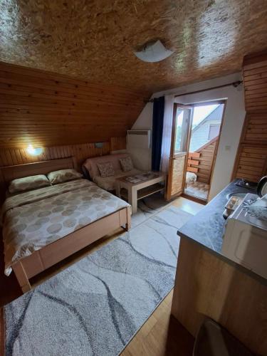 a bedroom with a bed and a table and a window at Apartment VUK in Žabljak