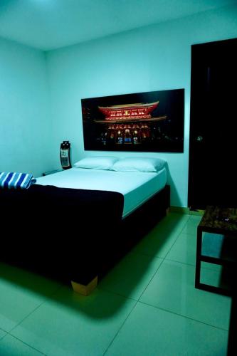 a bedroom with a large bed with a blue light at Hospedaje Parque Central frente al parque principal in Santa Rosa de Cabal