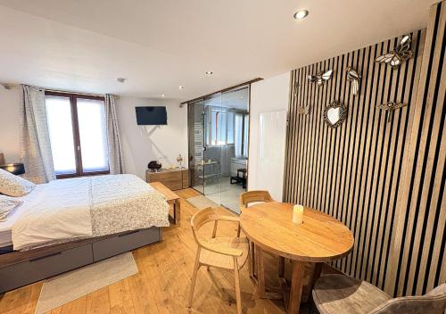 a bedroom with a bed and a table and a desk at Spa Privatif Montataire in Montataire