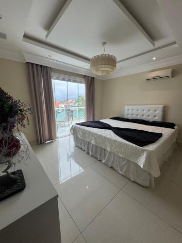 a bedroom with a bed and a large window at Mansão Bolsoni in Saquarema