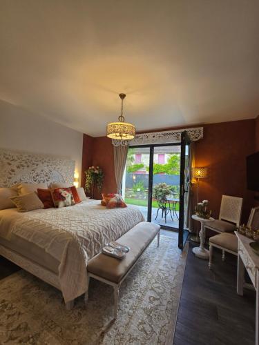 a bedroom with a large bed and a chandelier at La Villa M77 in Boitron