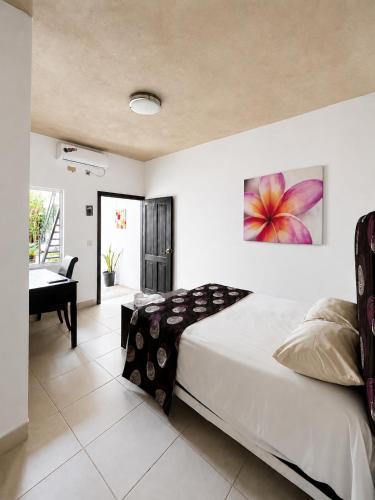 a bedroom with a bed and a desk and a piano at Casa Bugambilias in Tenosique de Pino Suárez