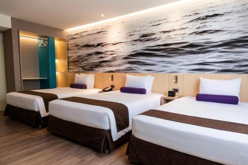 two beds in a hotel room with a painting on the wall at Palmetto Hotel Business San Borja in Lima