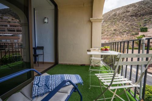 a porch with a table and chairs on a balcony at Noemi Blu Tenerife in Los Cristianos