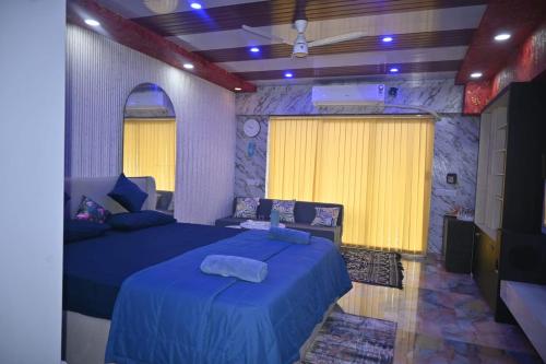 a bedroom with a blue bed and a yellow curtain at weston Hotel And Resorts in kolkata