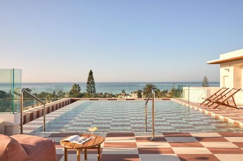a swimming pool on the roof of a house at Kimpton Los Monteros Marbella by IHG in Marbella