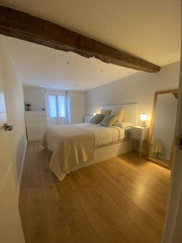 a bedroom with a large white bed and a mirror at Earra - Salegi - 2 minutos playa in Zarautz