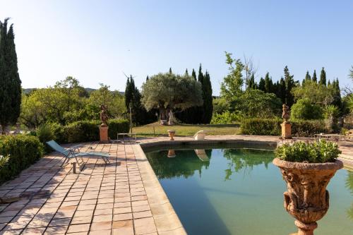 a swimming pool with a planter in a garden at Ecolodge Carpe Diem El Perelló in Perelló