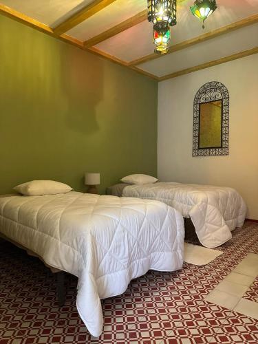 a room with two beds and a chandelier at Casa tio Manuel in São Martinho das Amoreiras