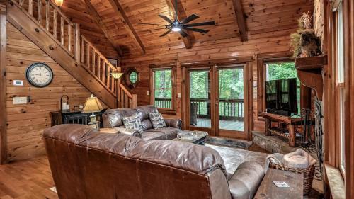 a living room with a couch and a clock in a cabin at Among the Trees in Epworth