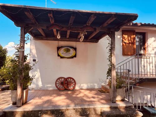 a white building with a wooden roof and a wheel at Antica Fiera in Caprese Michelangelo