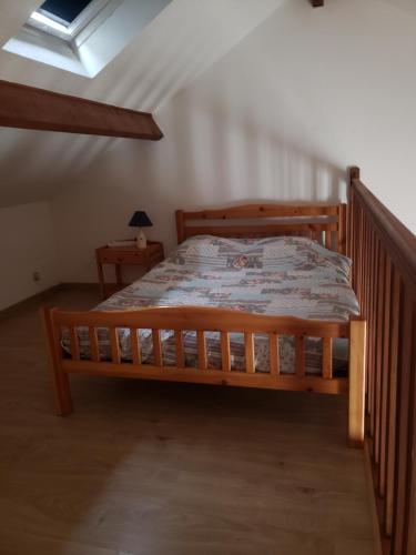 a wooden bed in a room with a window at Maison in Camiers