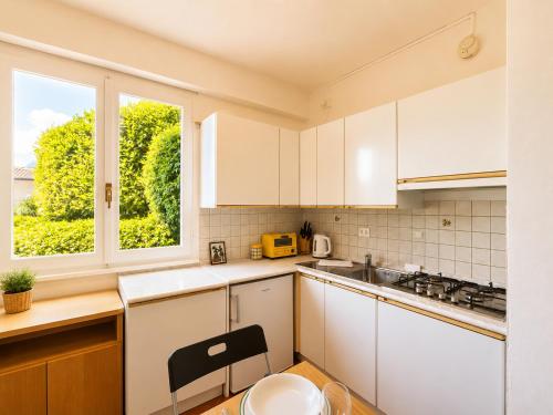 a kitchen with white cabinets and a window at Casa Leima - Larihome A83 in Gera Lario