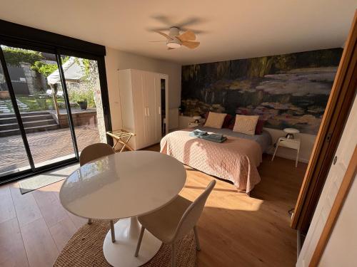 a bedroom with a table and a bed and a table and chairs at Maison Floréal Giverny in Giverny