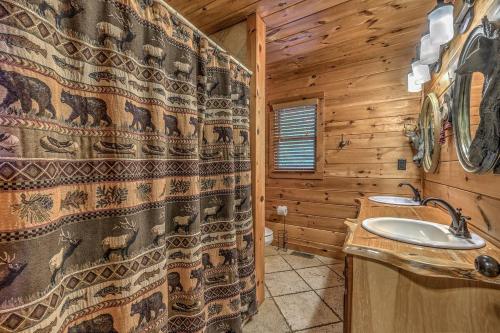 a bathroom with a shower curtain and a sink at Black Bear Lodge in Blue Ridge