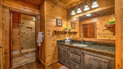 a log cabin bathroom with a sink and a shower at Falling Waters in Blue Ridge