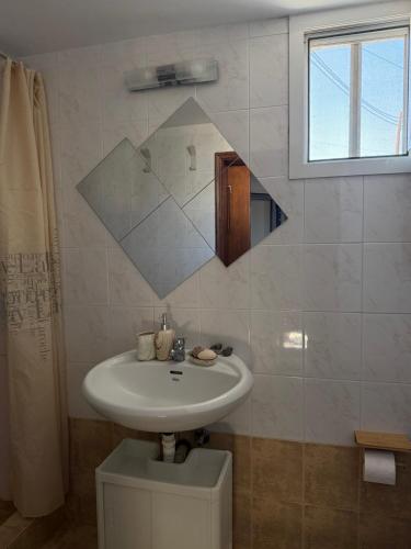 a bathroom with a sink and a mirror on the wall at Slow Living Home in Kilada