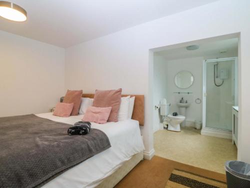 a bedroom with a large white bed with pink pillows at Jack's House in Tywyn