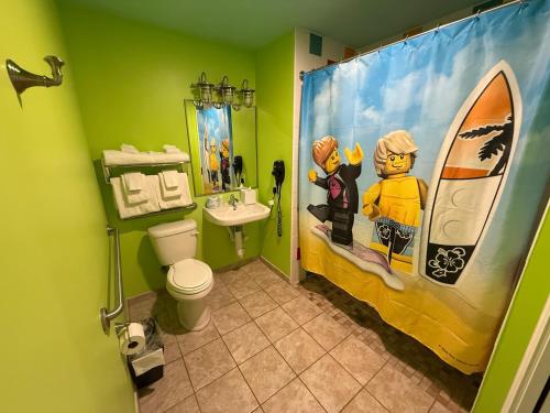 a bathroom with a toilet and a sink and a shower curtain at LEGOLAND® Florida Resort in Winter Haven
