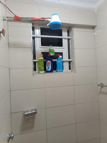 a window in a bathroom with cleaning products on it at Sky-Host, Dulham suite in Homa Bay