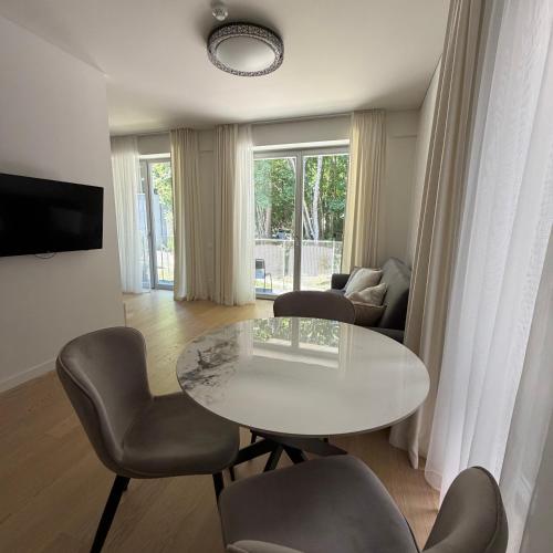a living room with a white table and chairs at Nerija in Juodkrantė