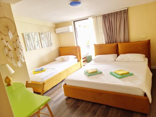 a hotel room with two beds and a green chair at SUNTAN Lovely Apartment in Golem