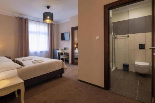 a bedroom with a bed and a bathroom with a shower at Royal Rooms Self Check-in in Poznań