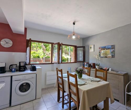 una cucina e una sala da pranzo con tavolo e sedie di Lavanda Calme et climatisé au cœur de Molitg les Bains a Moltig les Bains