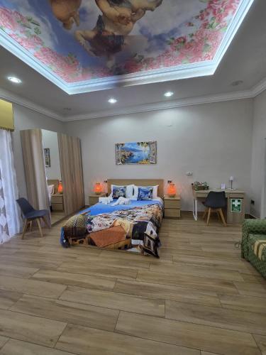 a bedroom with a bed and a ceiling with a mural at Maison de Ciro in Gragnano