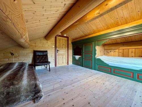 an attic room with a bed and a chair at Cabin in Tuddal in Hjartdal
