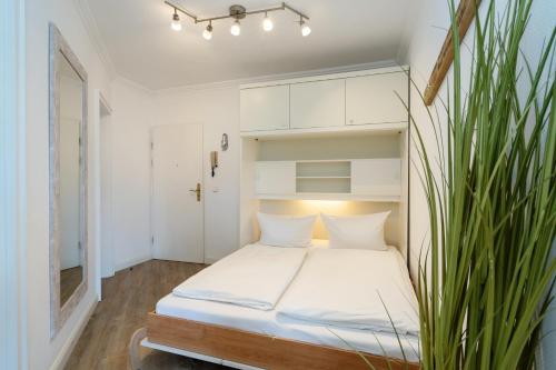 a bedroom with a bed with a plant at Syltliebe in Westerland
